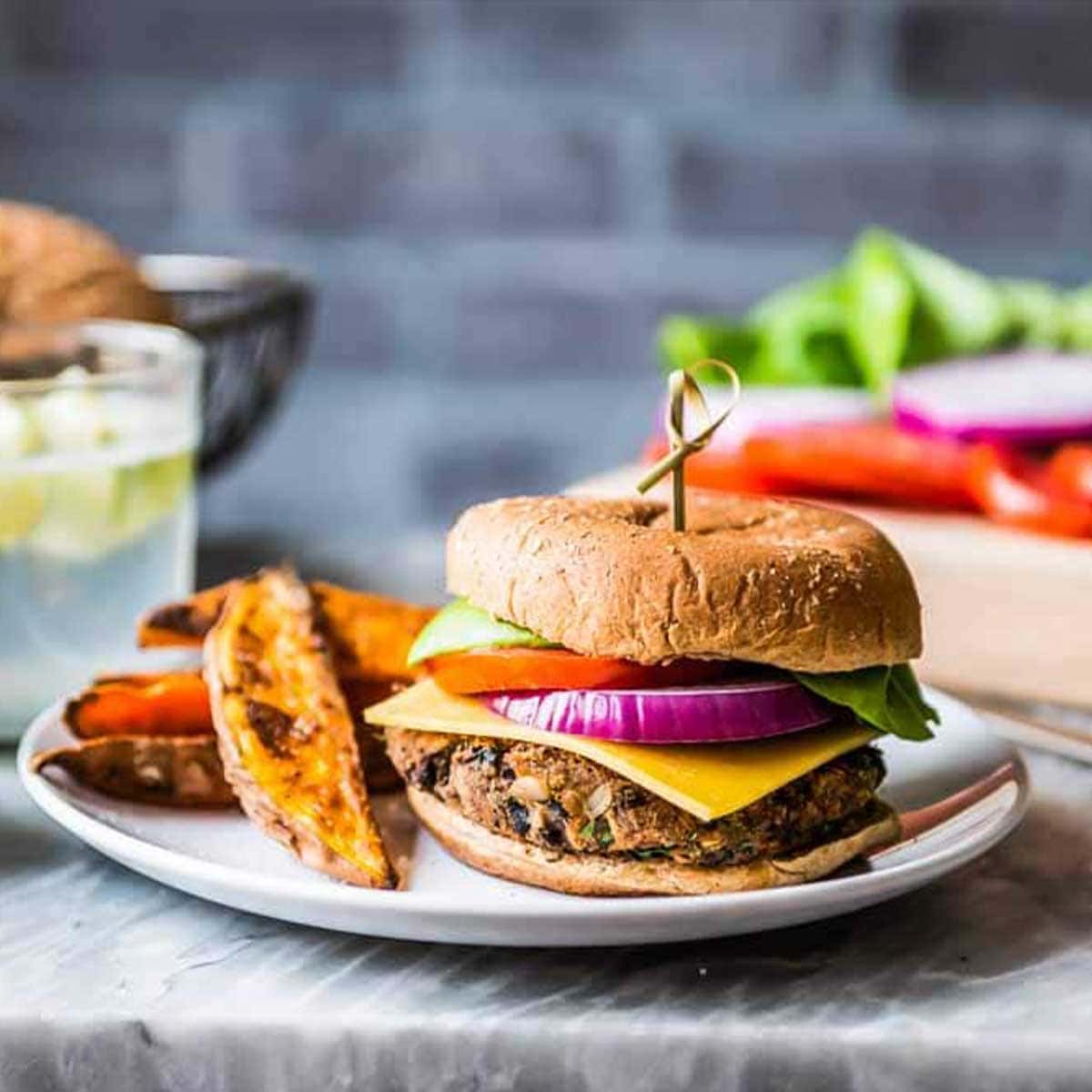 black bean burger with crispy sweet potato wedges on a plate.