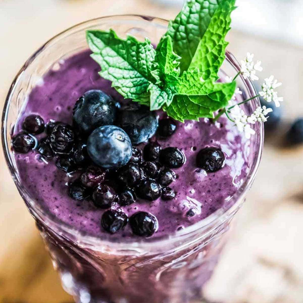 blueberry smoothie topped with blueberries and fresh mint.