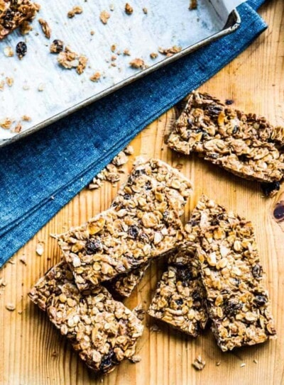 stack of homemade granola bars on a wooden counter top.