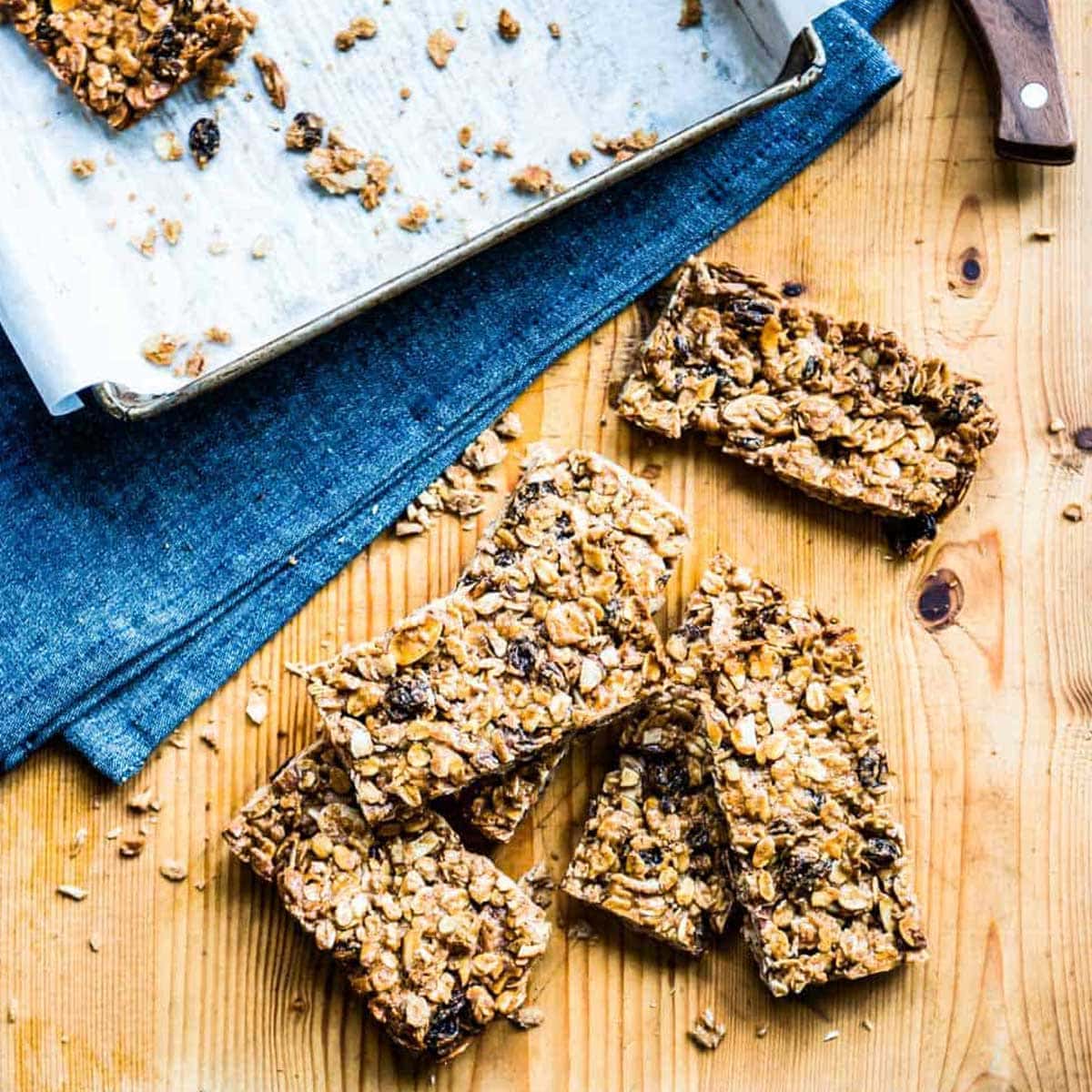 stack of homemade granola bars on a wooden counter top.