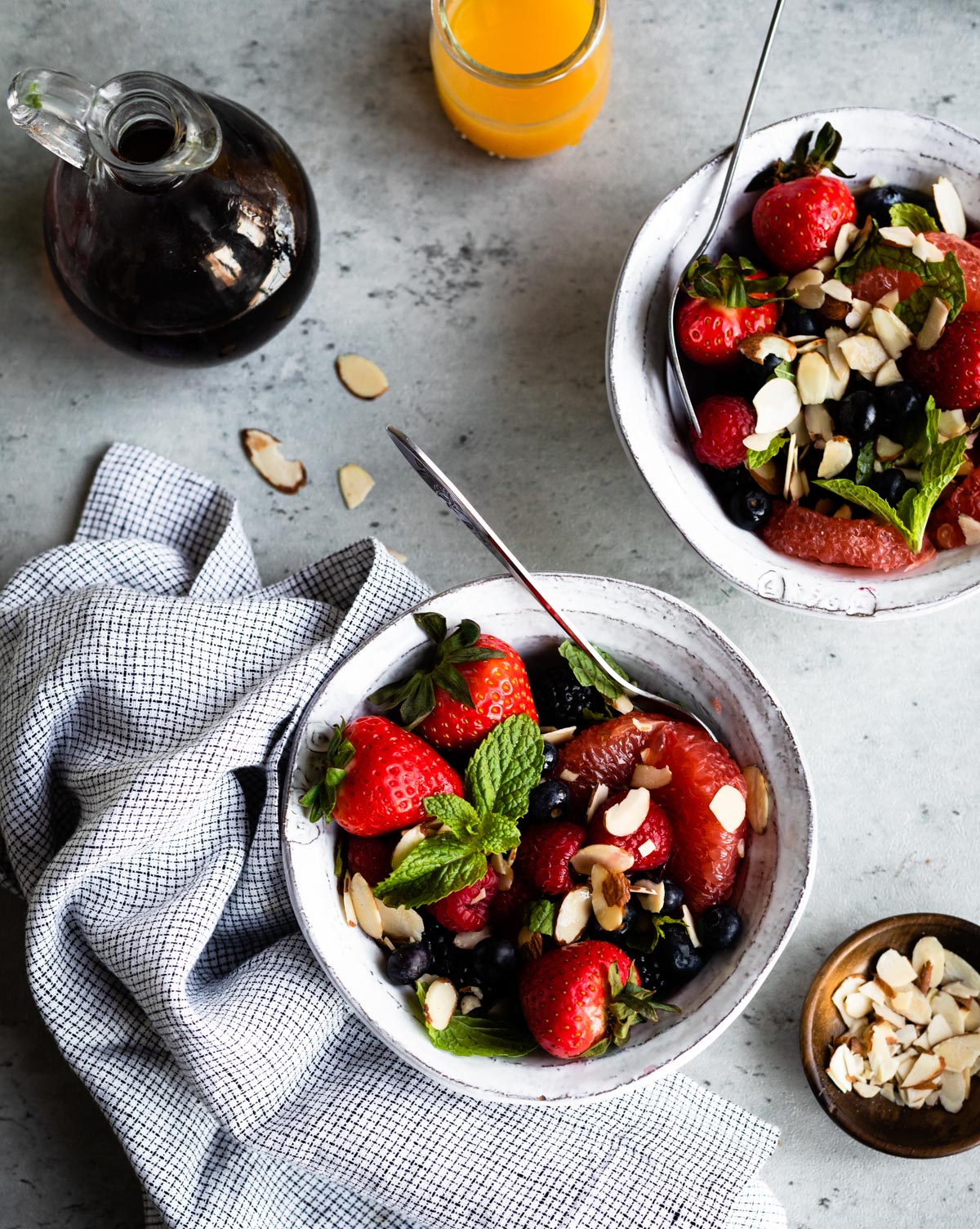 white bowl full of breakfast berry salad and a silver spoon.