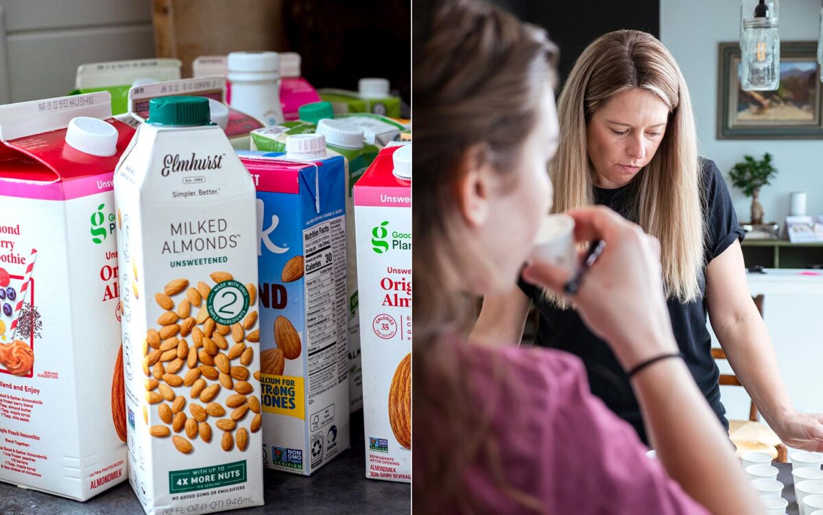 several different brands of nut milk on a counter and 2 females taste testing milk in small white cups.