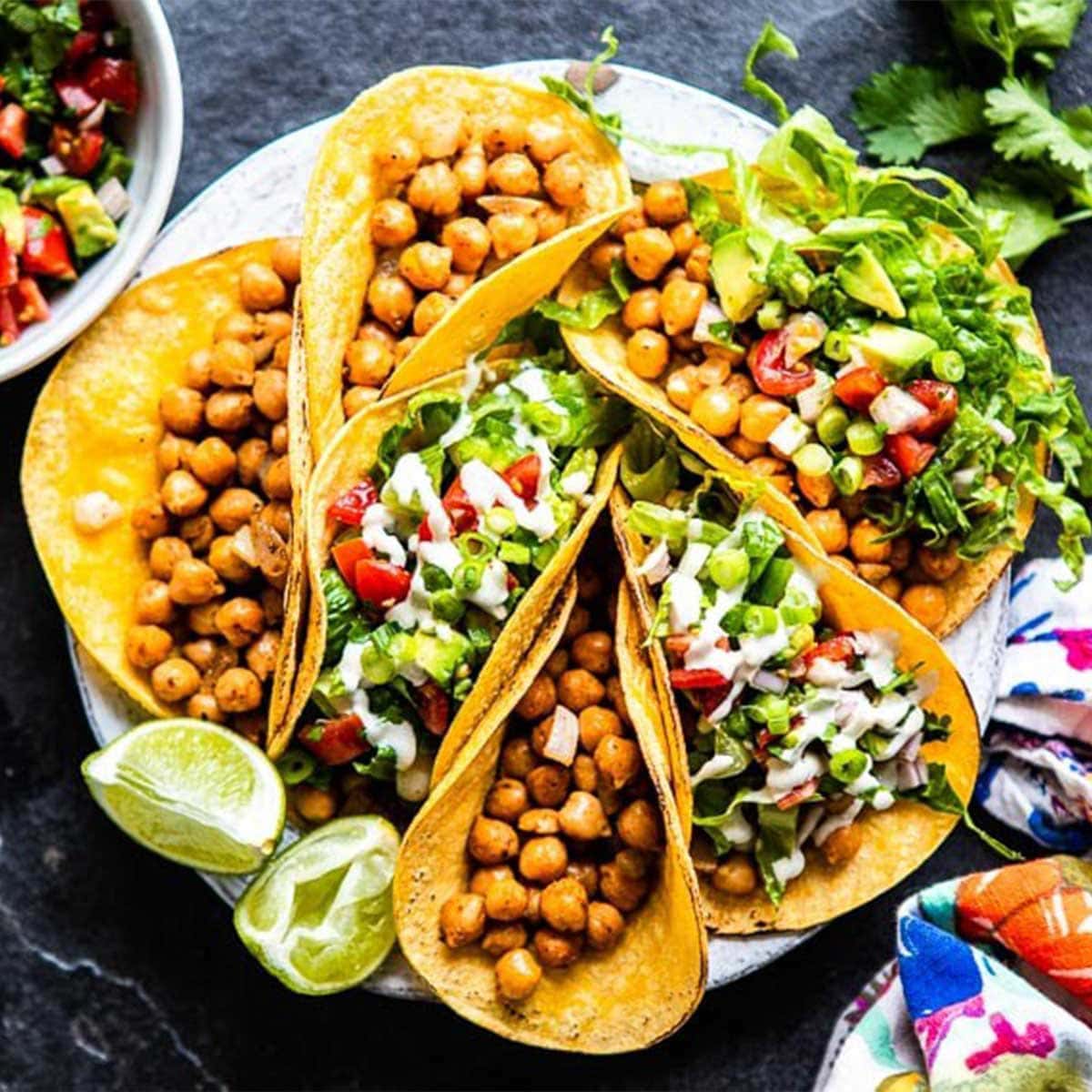 a plate full of chickpea tacos with fresh toppings