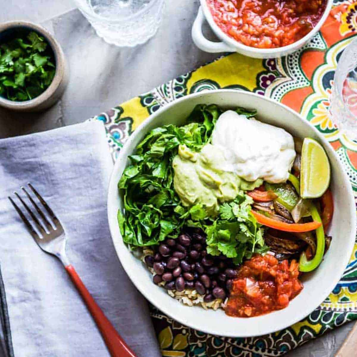 A colorful chipotle veggie bowl with a fork.