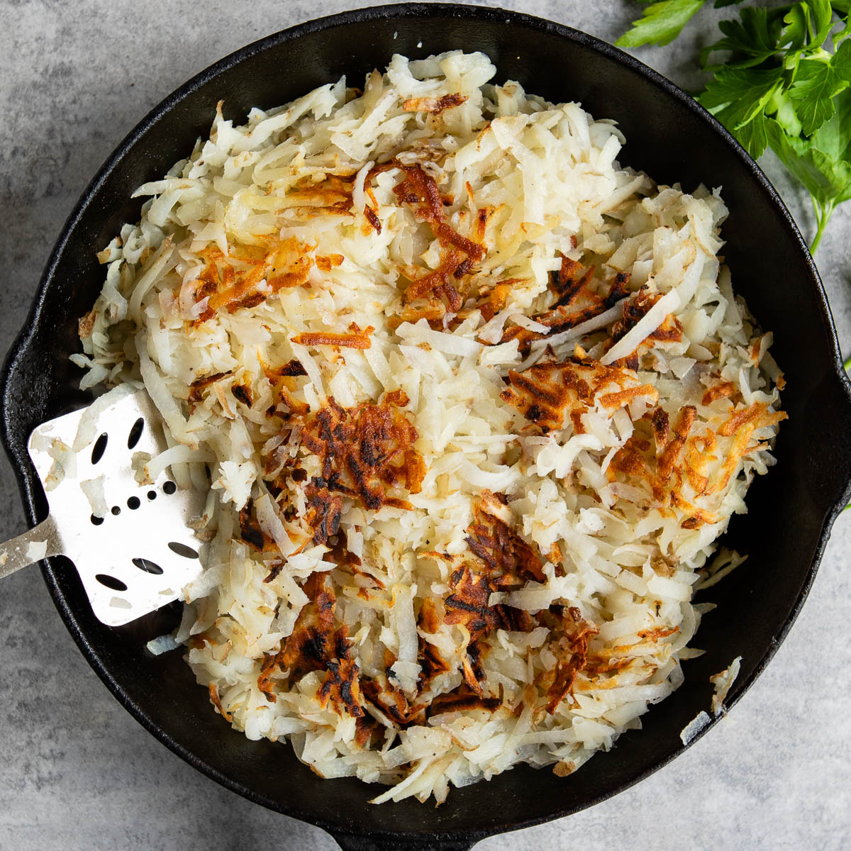 Hash Browns cooking in a cast iron skillet