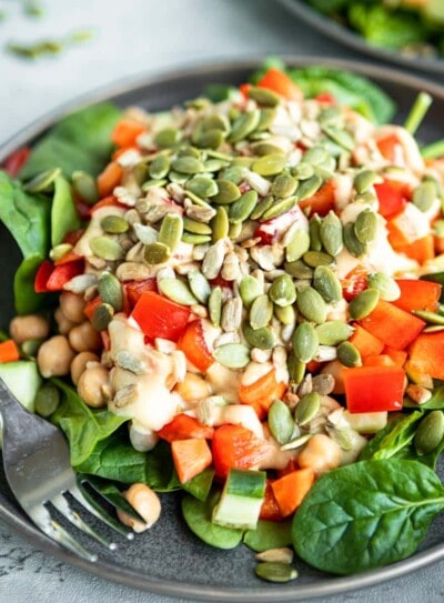 chickpea salad on a gray plate with a stainless steel fork.