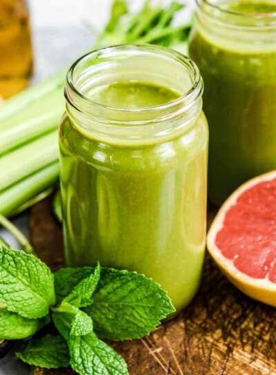 Two mason jars full of fat burning smoothies for weight loss, with ingredients around.