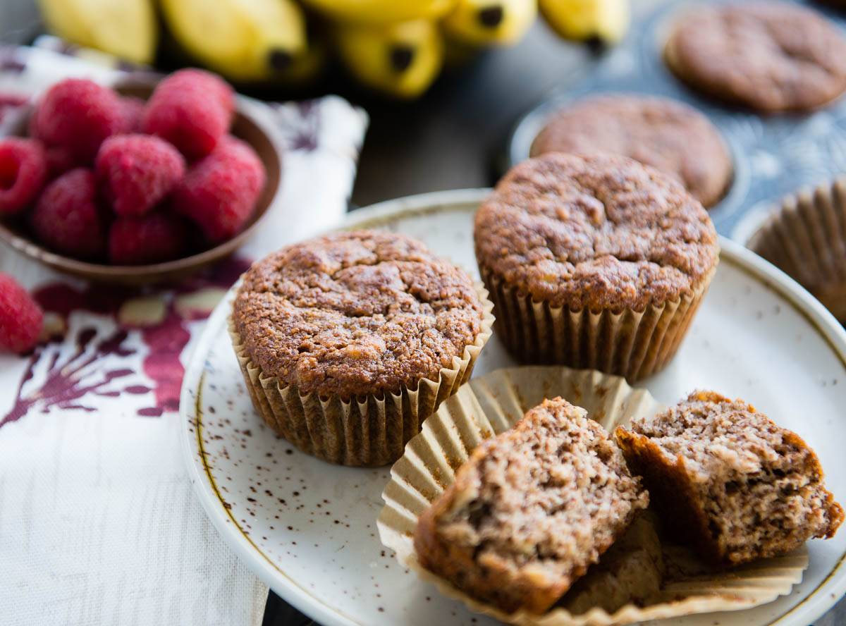 a plate with 2 whole gluten-free banana muffins and one broken in half.