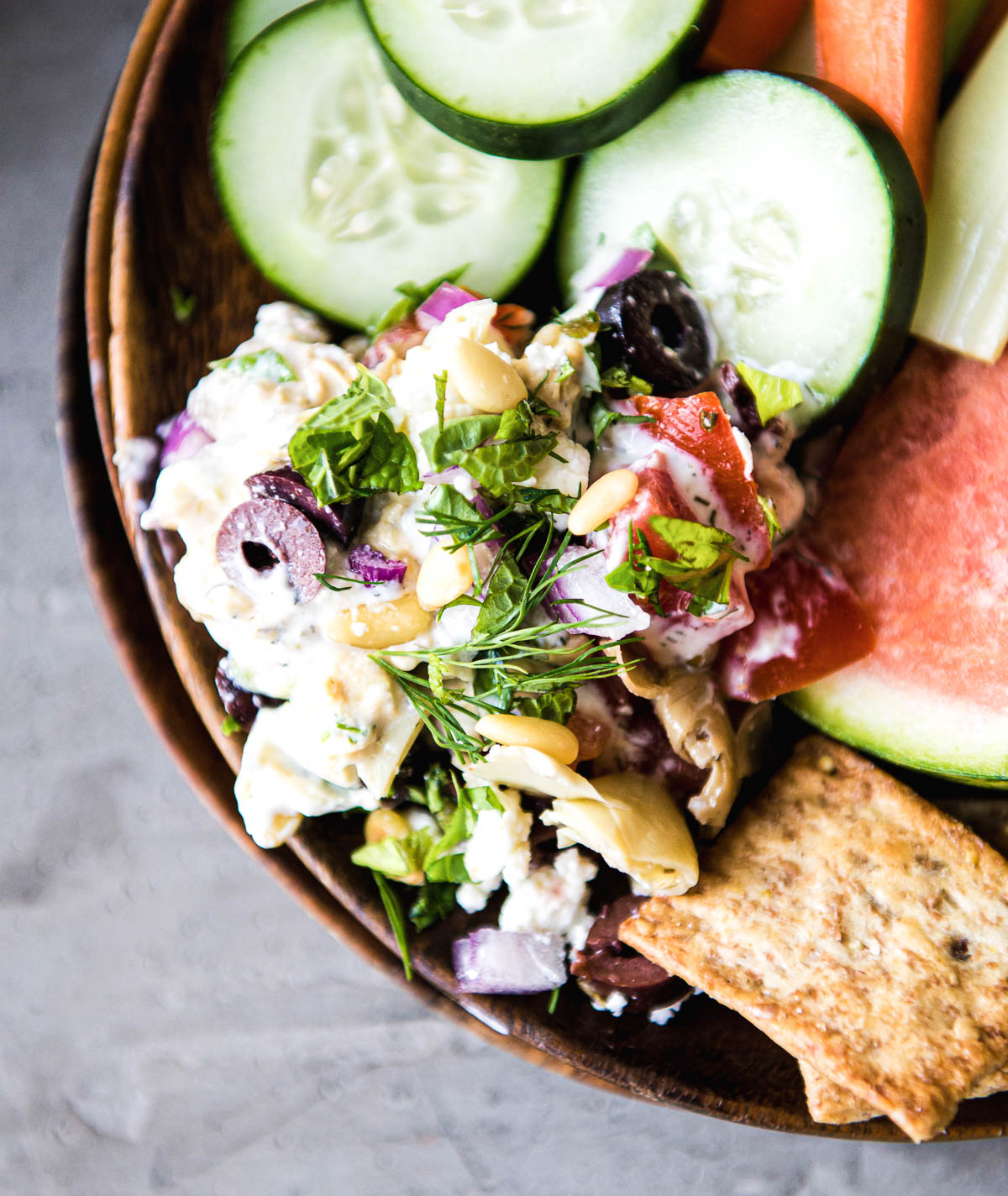 close up of a scoop of layered dip on a tray of appetizers