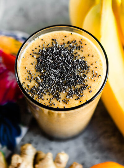 orange hangover smoothie in glass topped with black chia seeds.