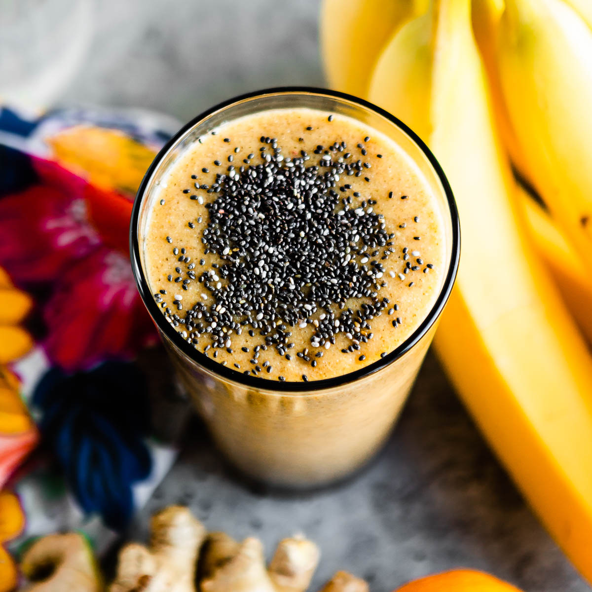 orange hangover smoothie in glass topped with black chia seeds.