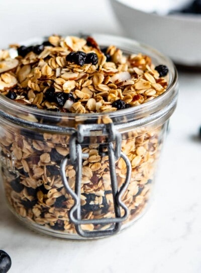 healthy granola in a glass jar with dried blueberries.