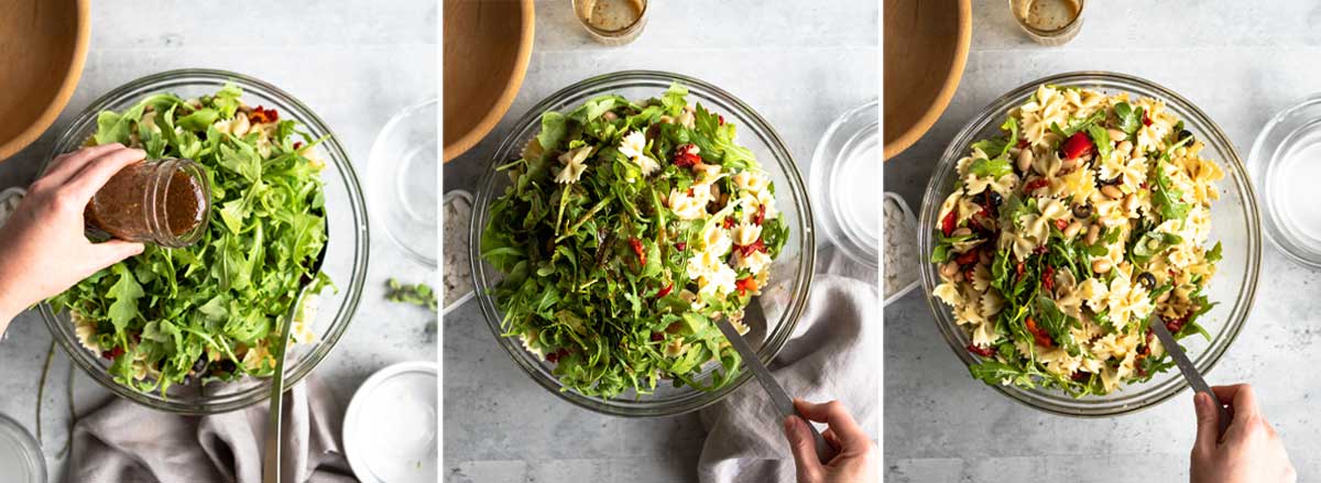 pouring homemade dressing over vegan pasta salad, then tossing the salad to incorporate.