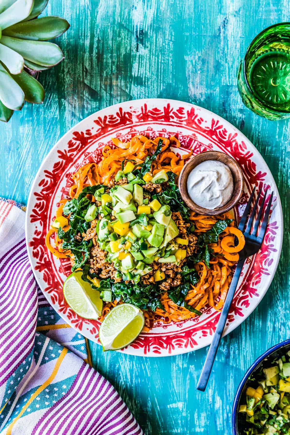 Spiralized Vegetarian Taco Salad on a brightly decorated plate with a black fork.