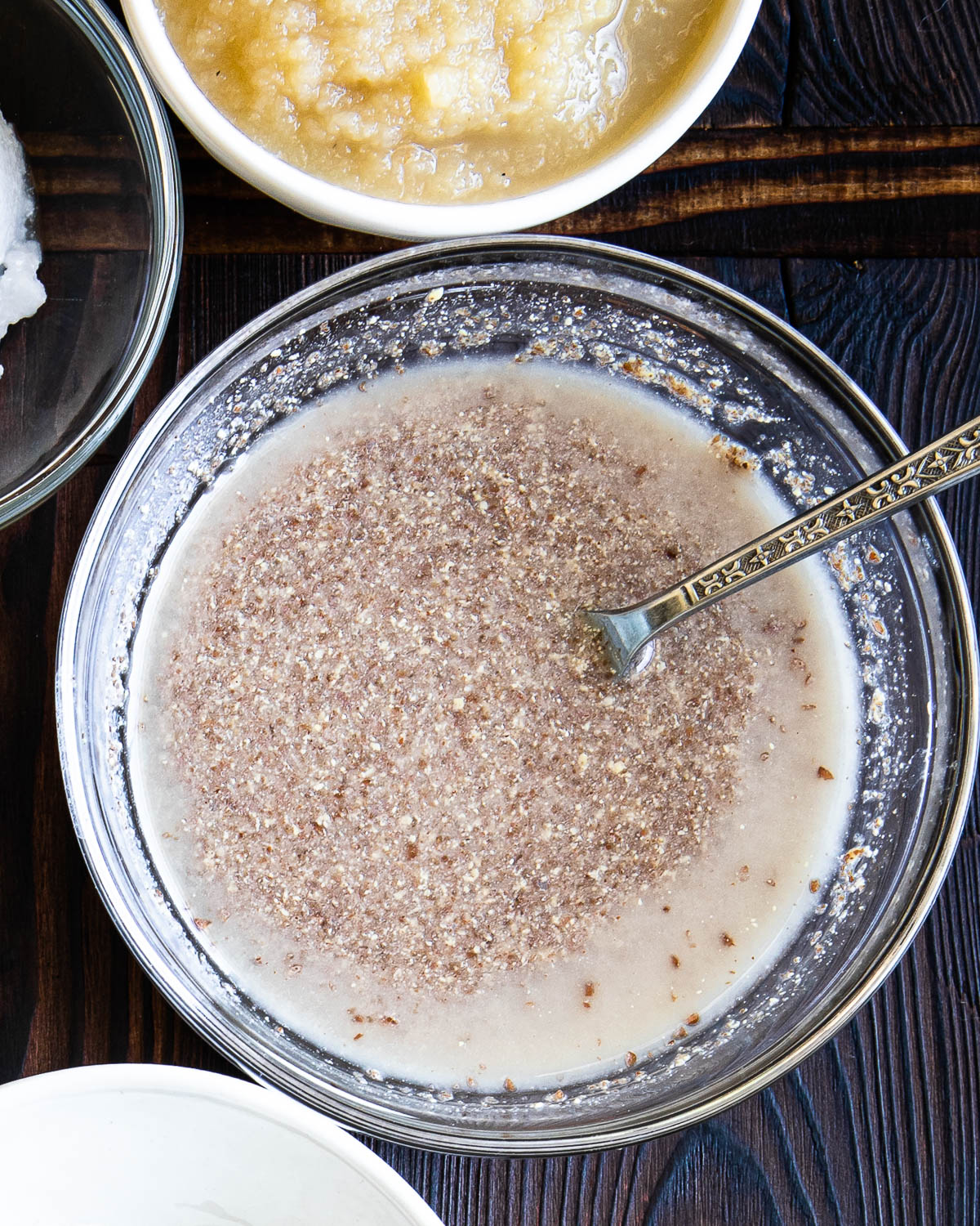 glass bowl with flax egg mixture and a silver spoon.