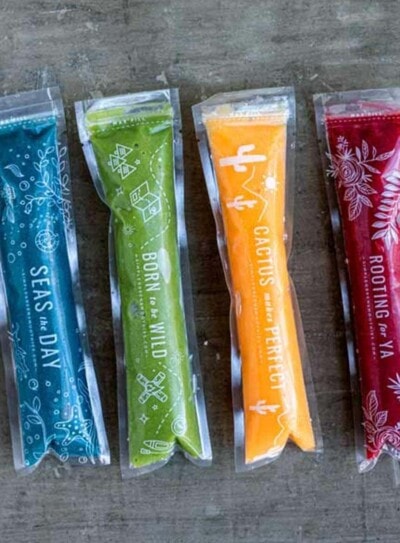 4 plastic sleeves filled with healthy homemade popsicles in blue, green, yellow and red.