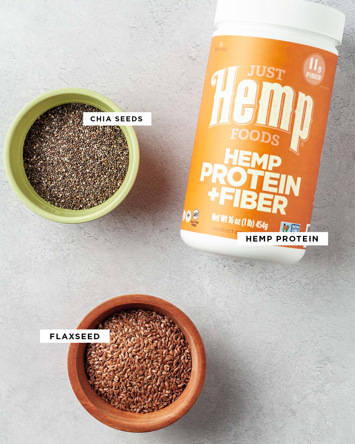 Labeled ingredients to make homemade protein powder recipe with chia seeds, hemp protein and flaxseed.