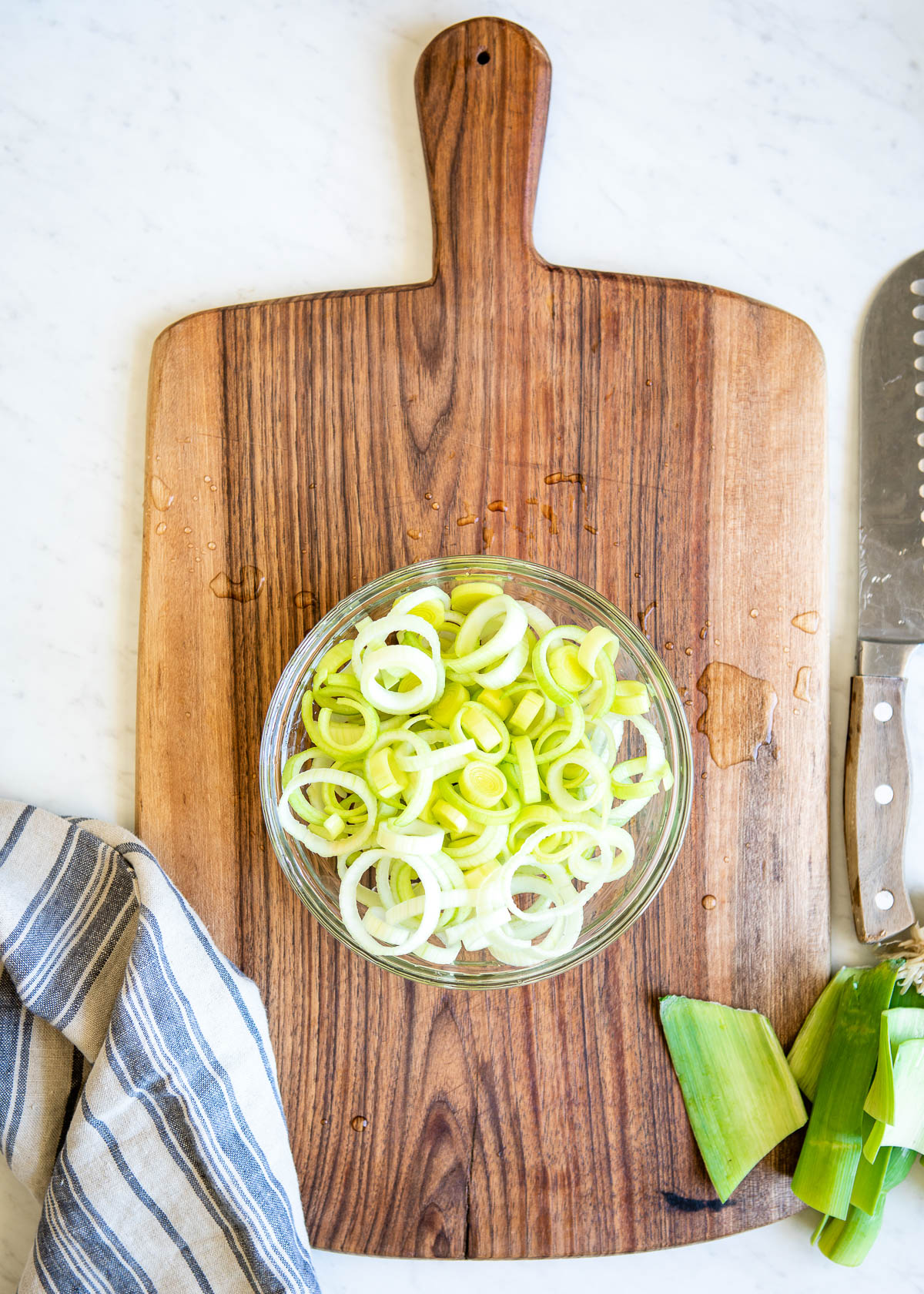 clear glass bowl of freshly washed leek slices ready for cooking.