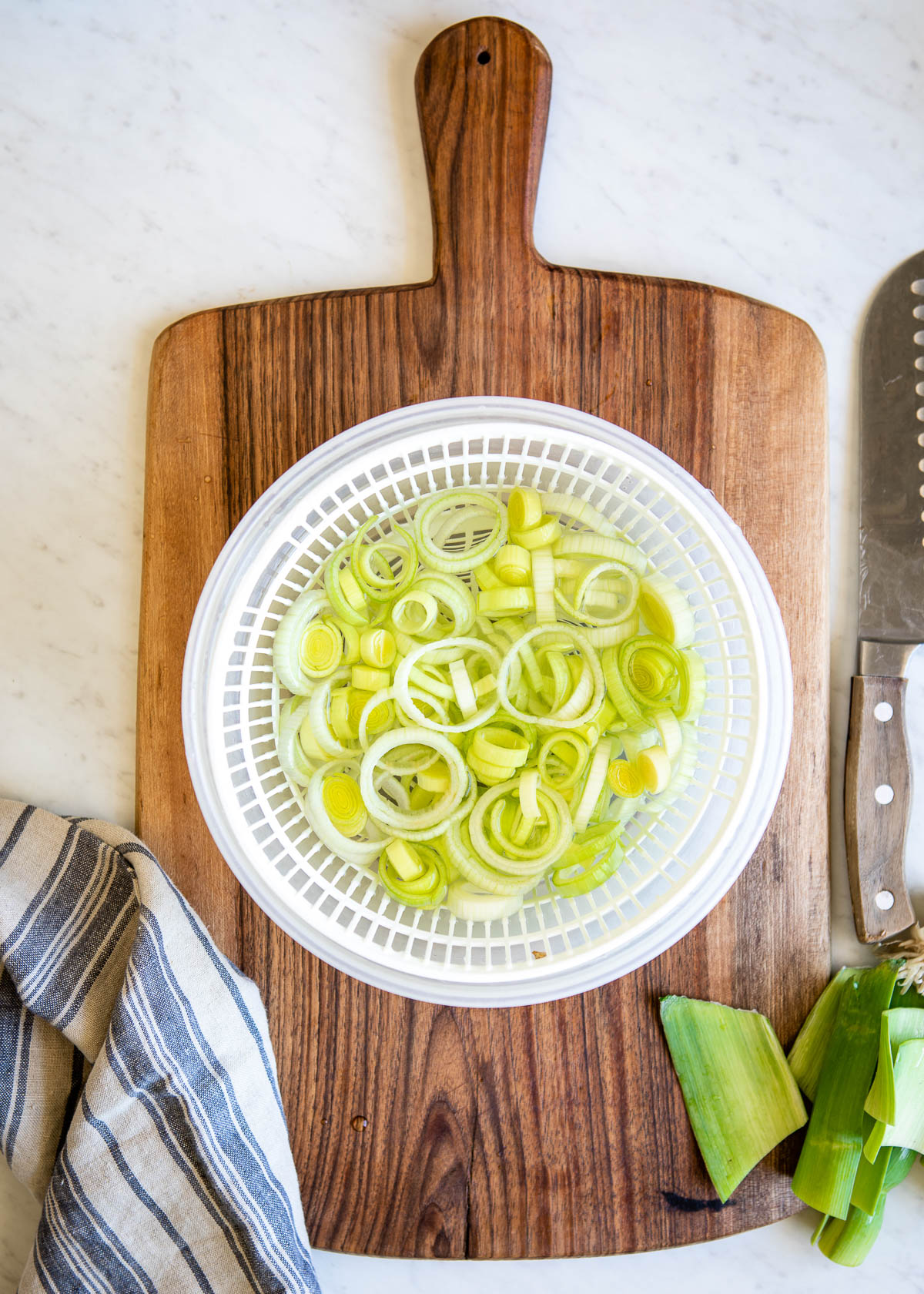 thin sliced circles of leek in a colander.