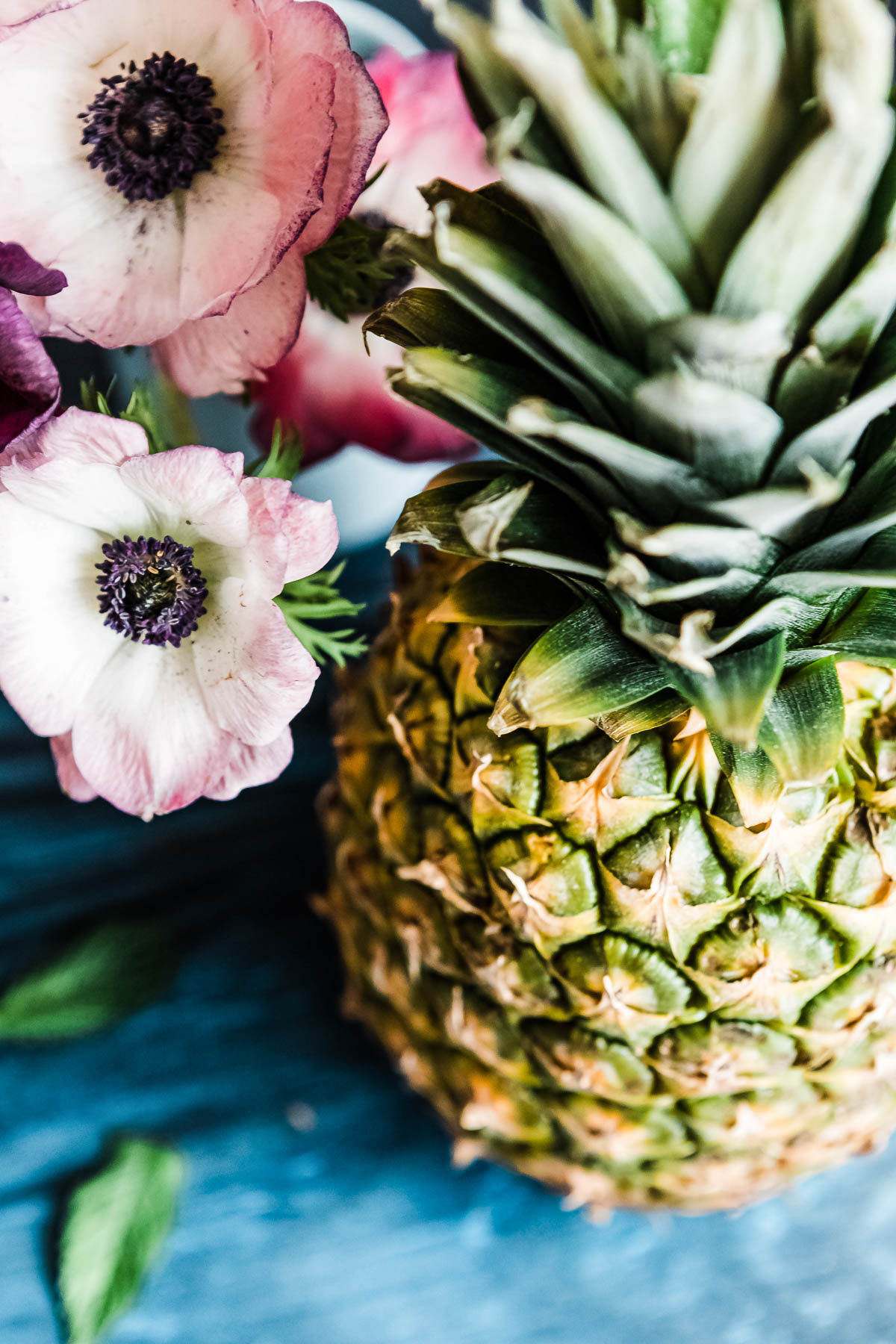 pink flowers next to a whole pineapple.