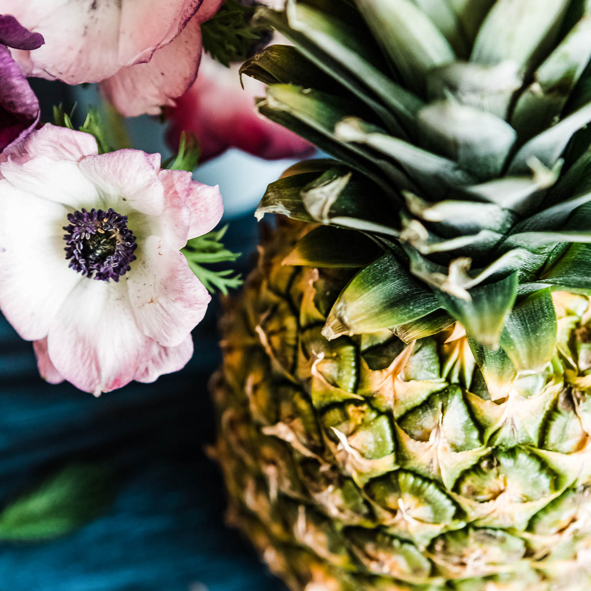 pink flowers next to a whole pineapple.