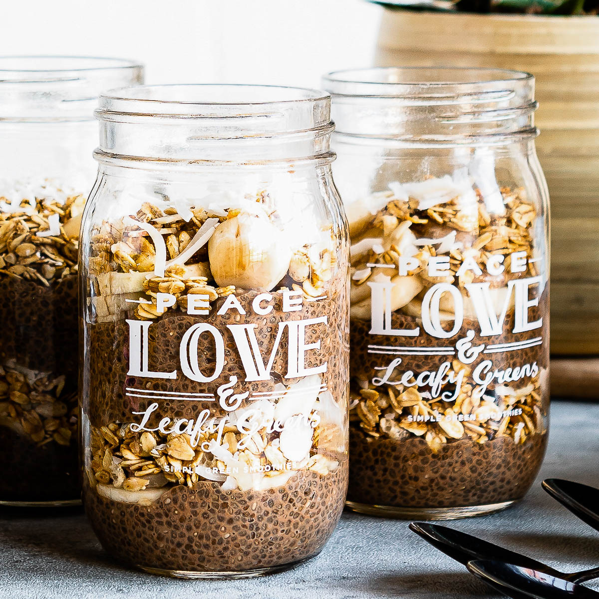 3 jars of chocolate chia pudding layered with fresh fruit and granola.