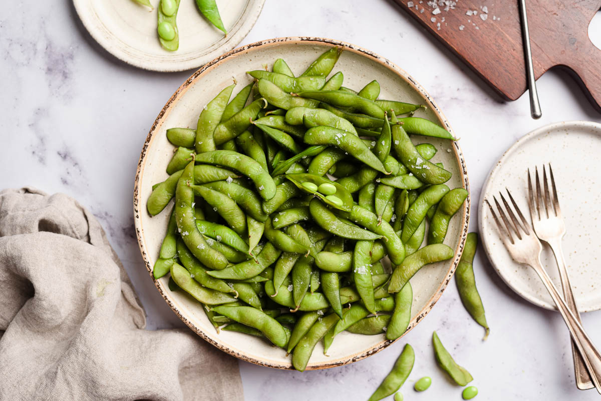 plate of boiled edamame sprinkled with coarse salt.