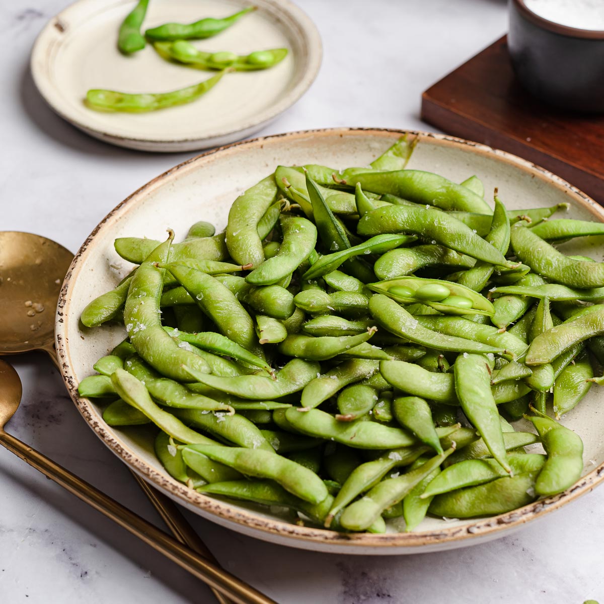 ceramic plate of boiled edamame.