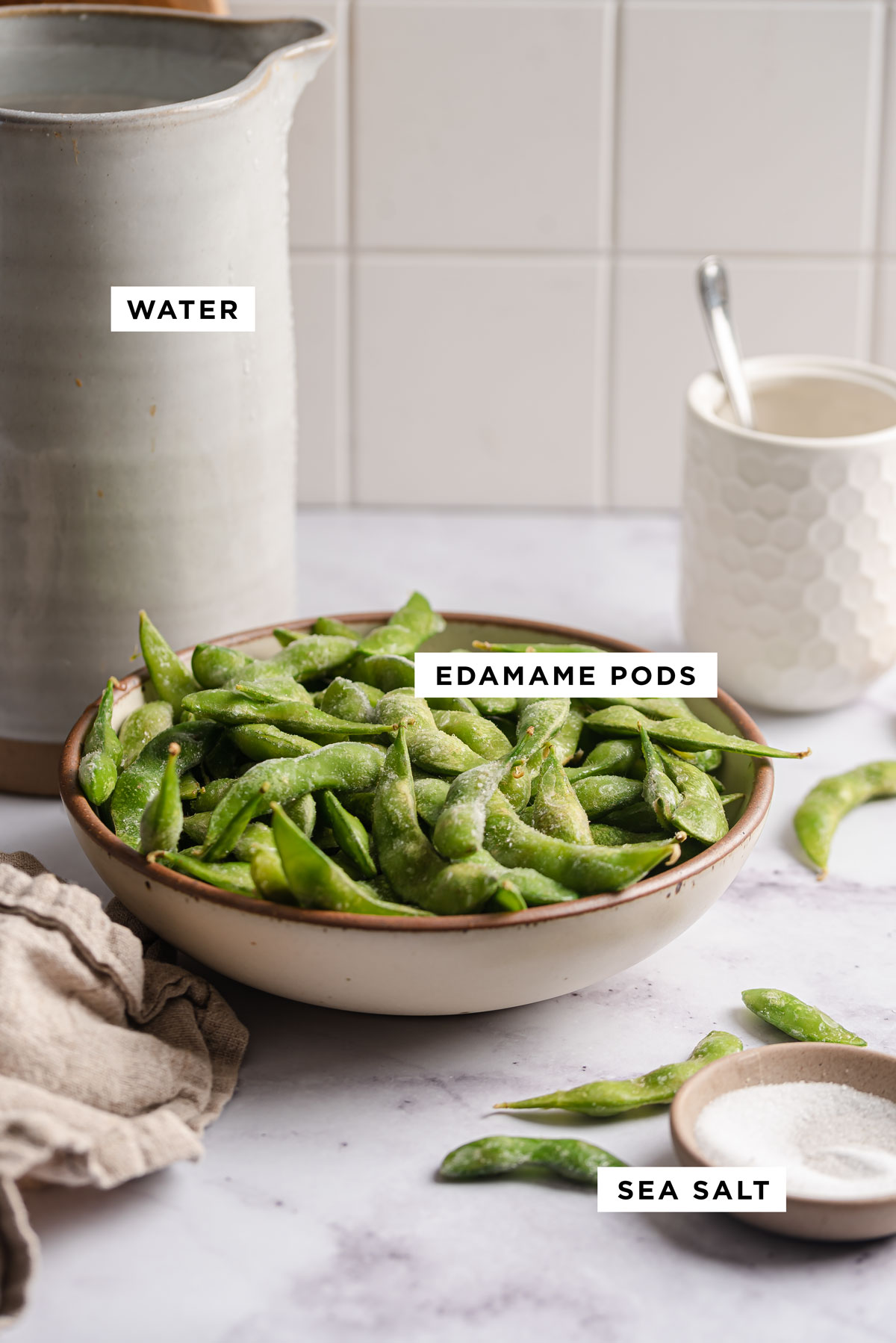 labeled ingredients for how to make edamame including water, edamame pods and sea salt.