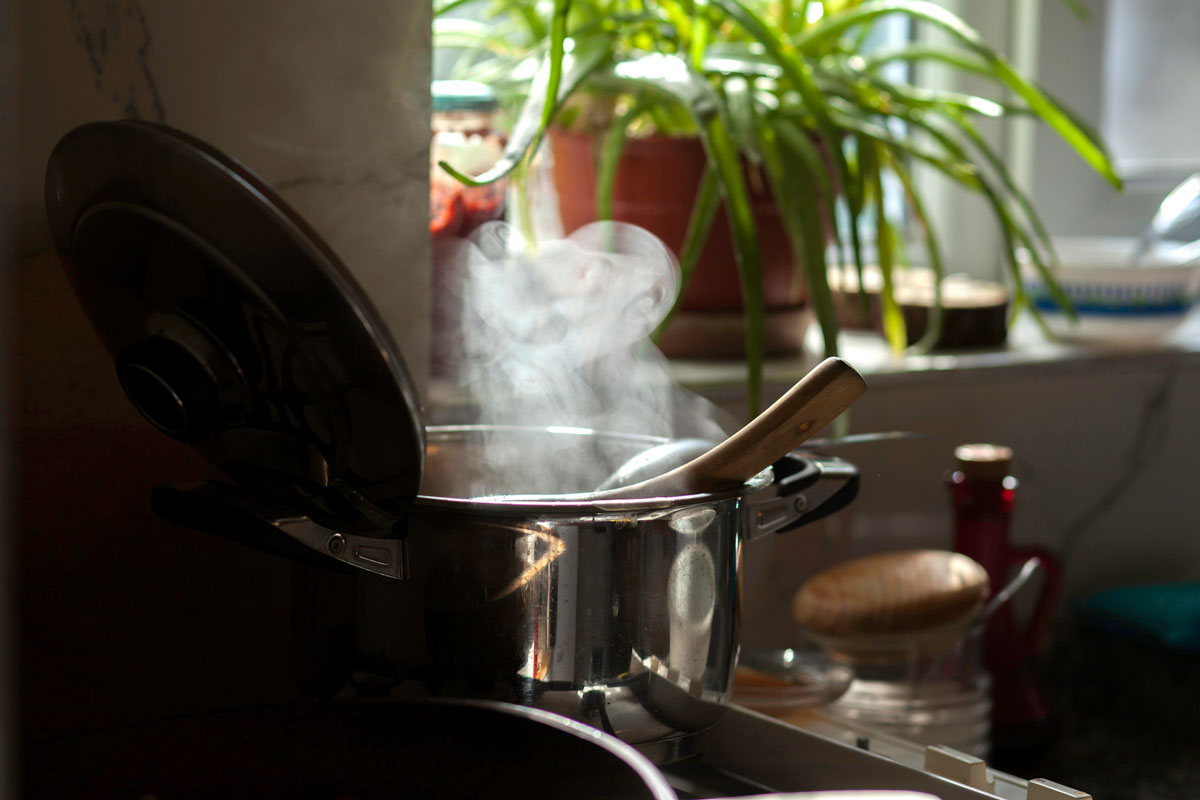 Stainless steel pot of tomato soup on stove.