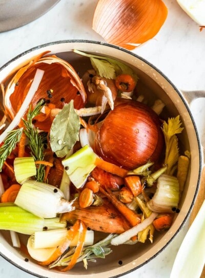 white stock pot full of vegetable scrapes for vegetable stock recipe.