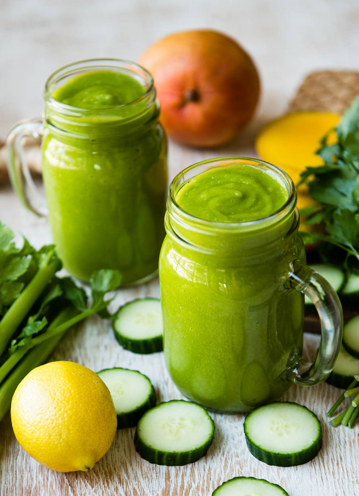 Immune boosting smoothie in two glass jars surrounded by fresh ingredients.