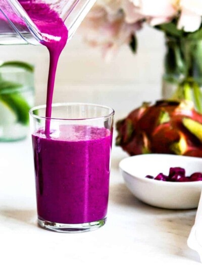 Immune boosting smoothie recipe getting poured into a clear glass.