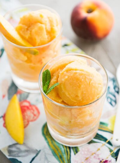 2 glasses of fresh mango sorbet on a colorful tea towel.