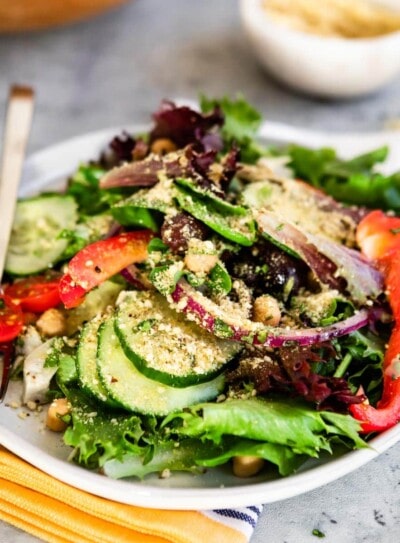 greek salad on a white plate with a fork.