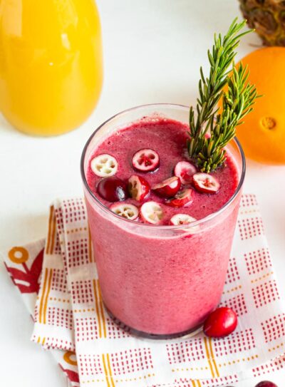 Orange cranberry smoothie in a tall glass.