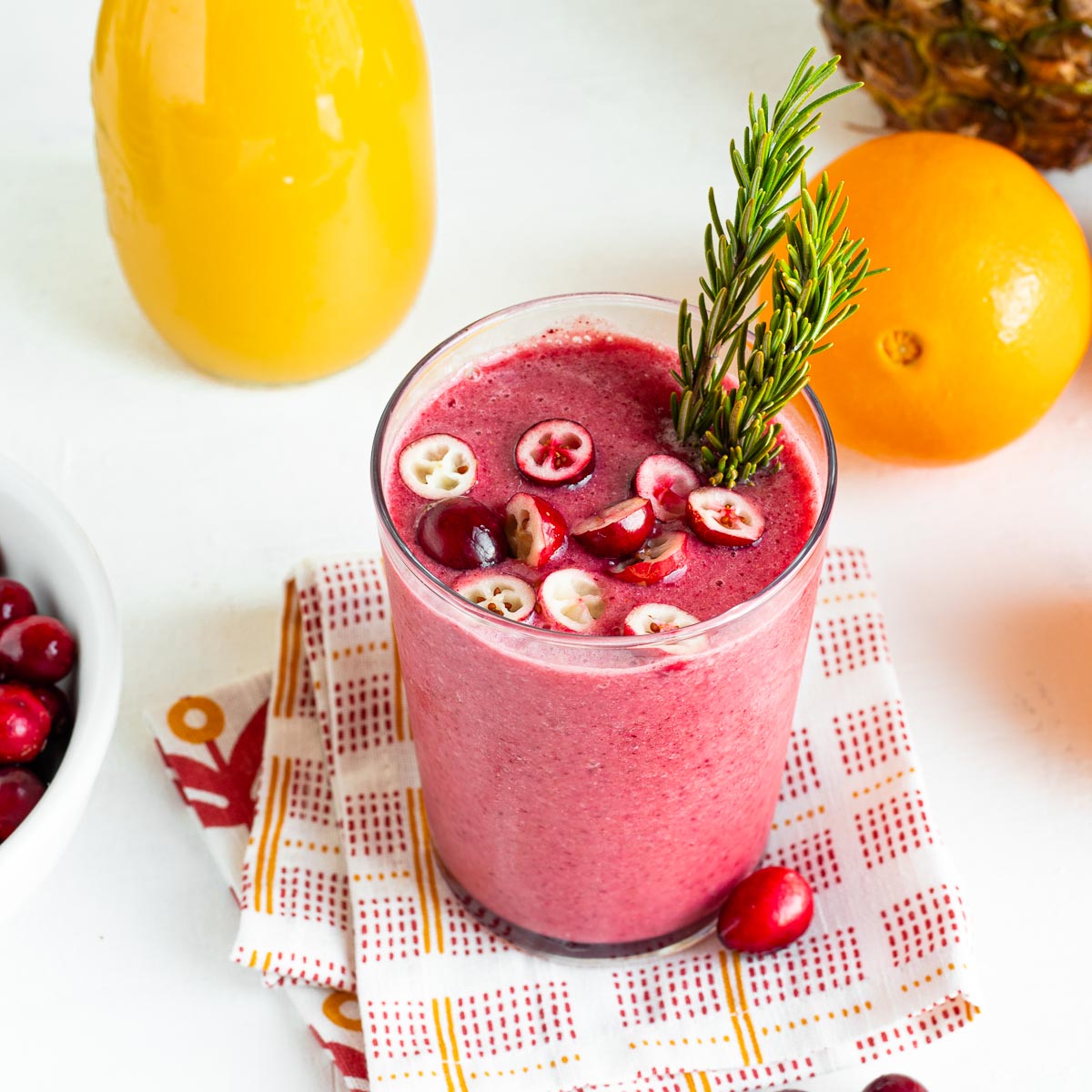 Orange cranberry smoothie in a tall glass.