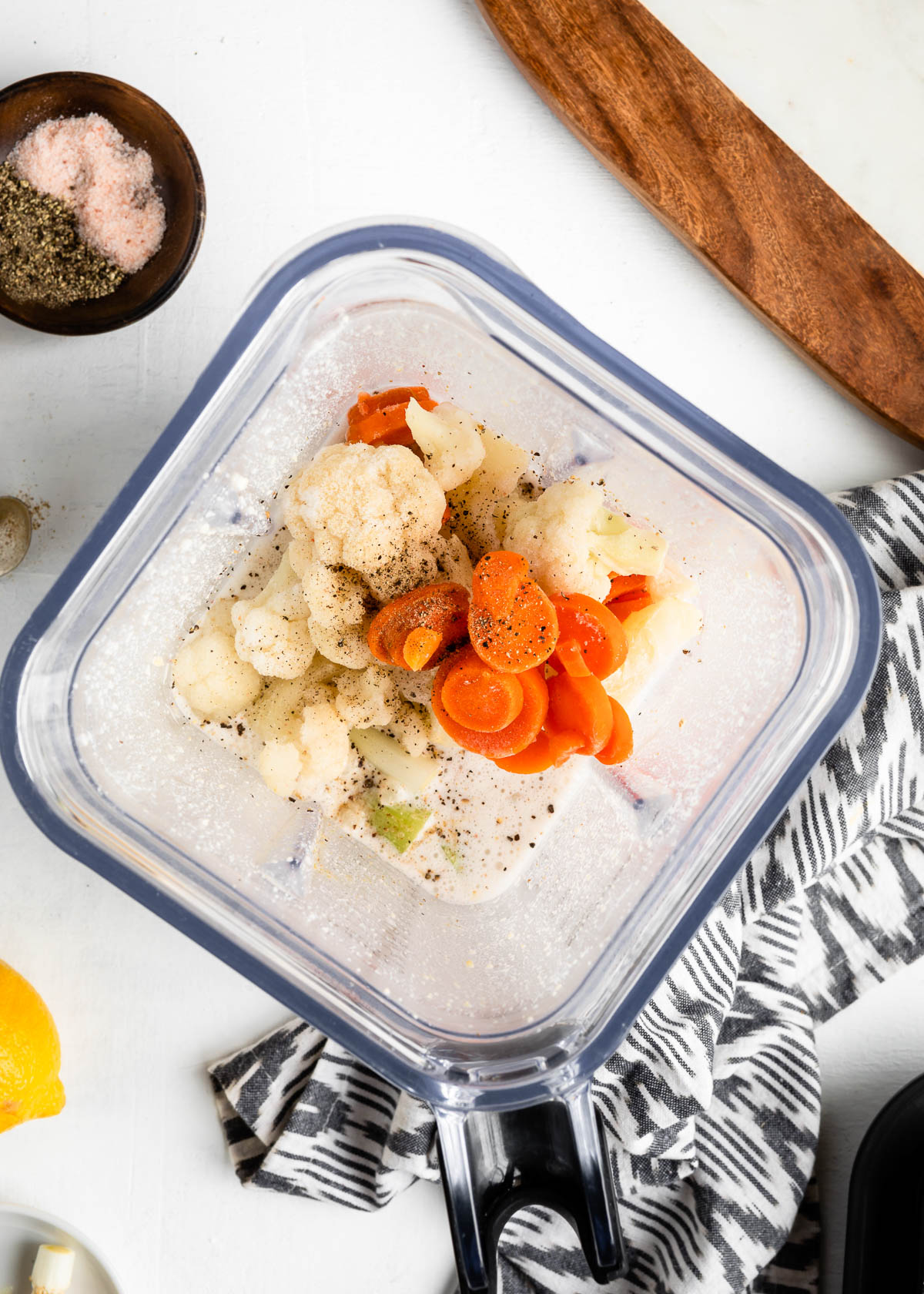 blender container filled with ingredients for a smoothie with cauliflower.