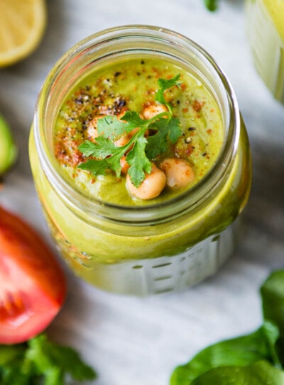 overhead photo of a savory protein shake in a glass jar topped with chickpeas and spices