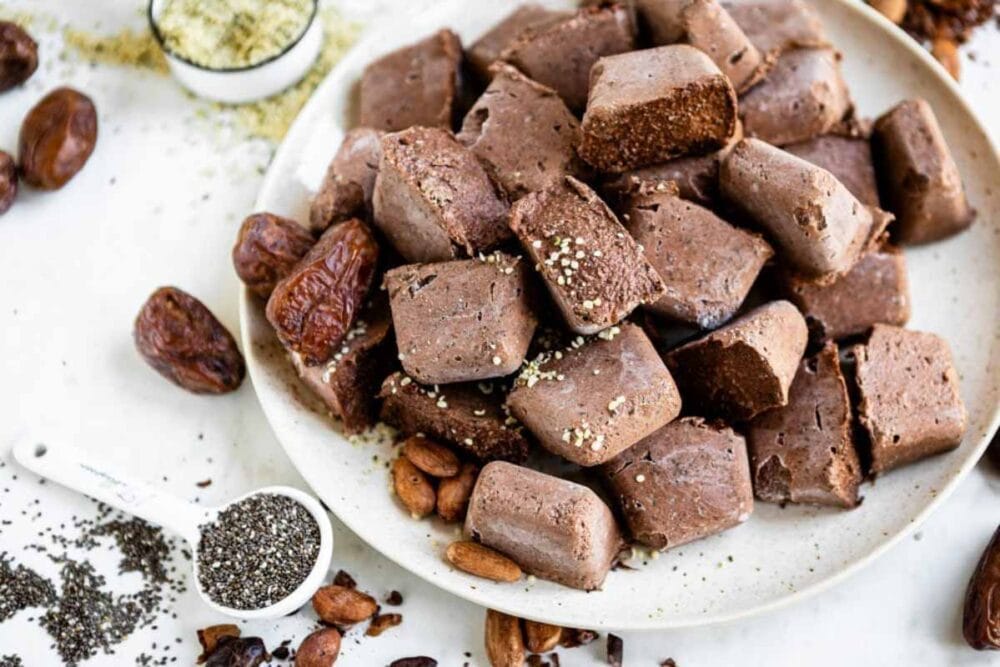 plate of fiber smoothie cubes next to a tablespoon full of chia seeds.