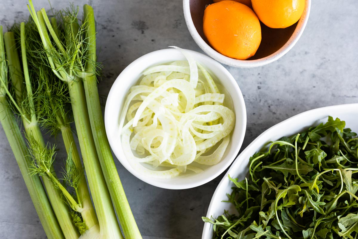 fennel, lemon and arugula in white bowls.