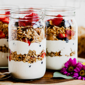 3 glass jars full of vegan yogurt parfaits.