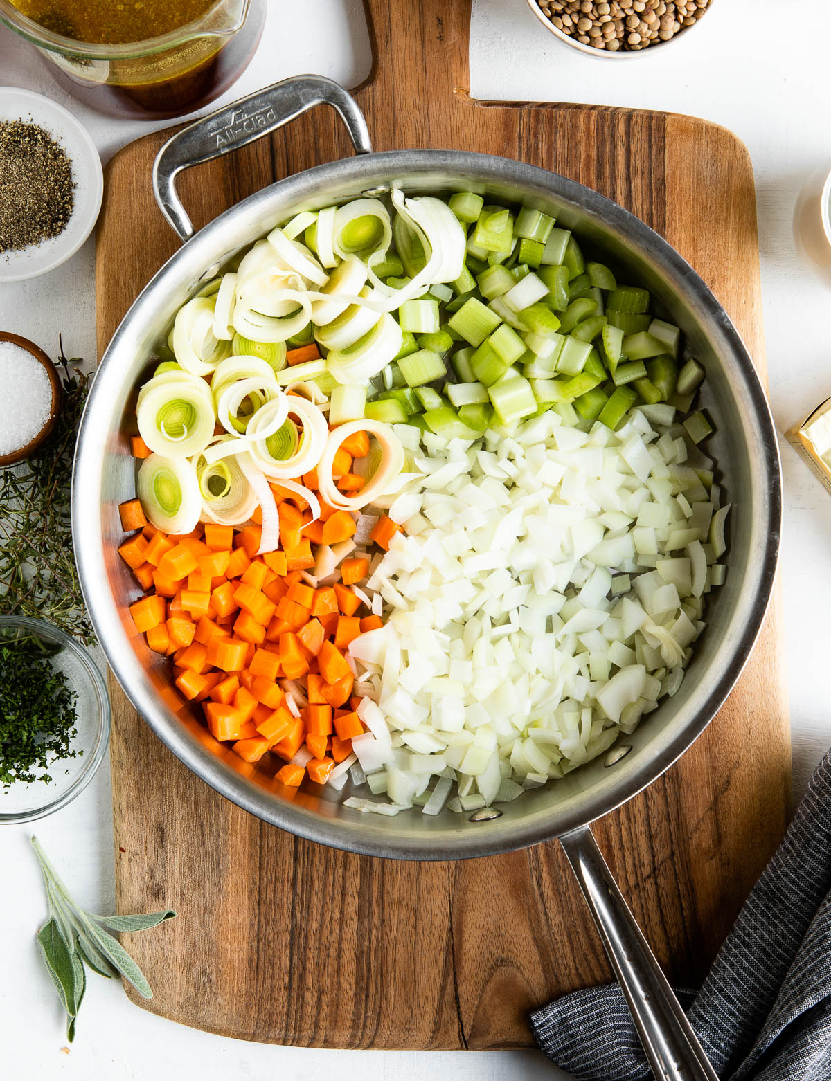 stainless steel skillet full of chopped vegetables ready to be sautéd.