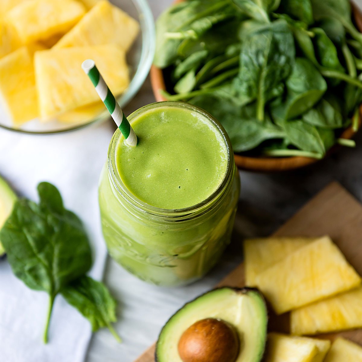 tropical smoothie in glass jar with stripped straw.