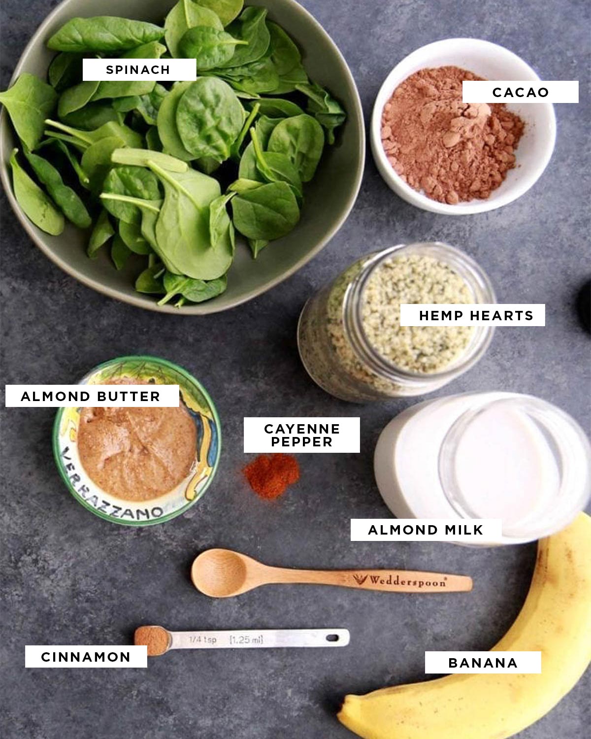 Weight loss shake ingredients labeled with white boxes and black text, featuring spinach, cacao, hemp hearts, almond butter, cayenne pepper, almond milk, cinnamon, and banana.