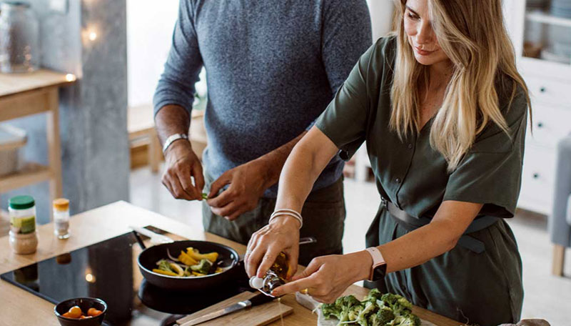 Man and women in the kitchen preparing cleanse dinner recipes.