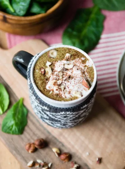 hot chocolate smoothie in mug with sweater wrap, topped with coconut whipped cream.